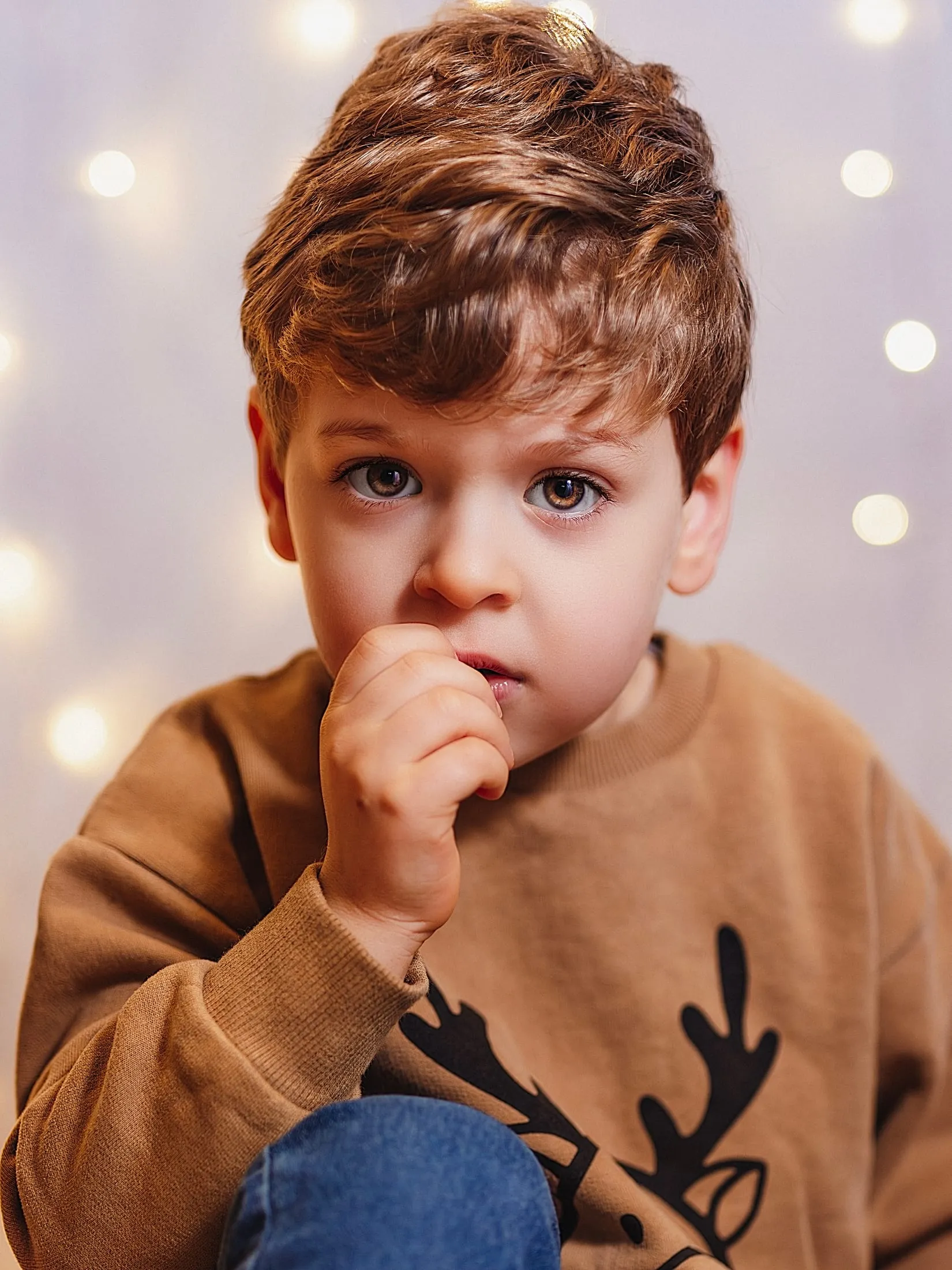 Young boy in a knitted jumper in low, warm light